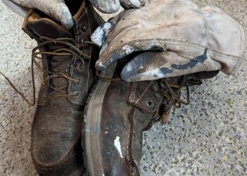 worn leather gloves and work boots