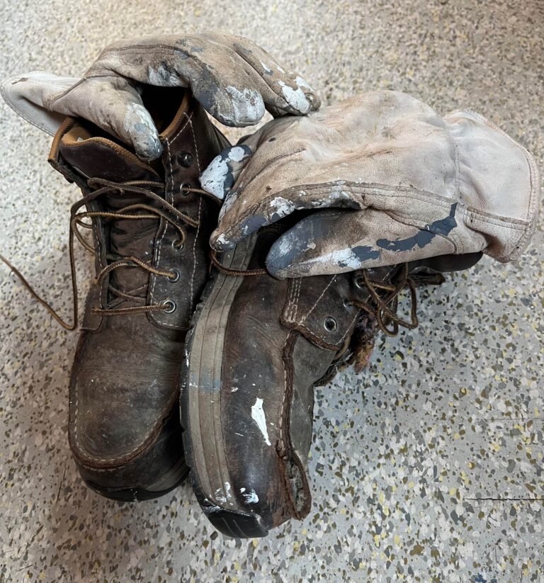 worn leather gloves and work boots