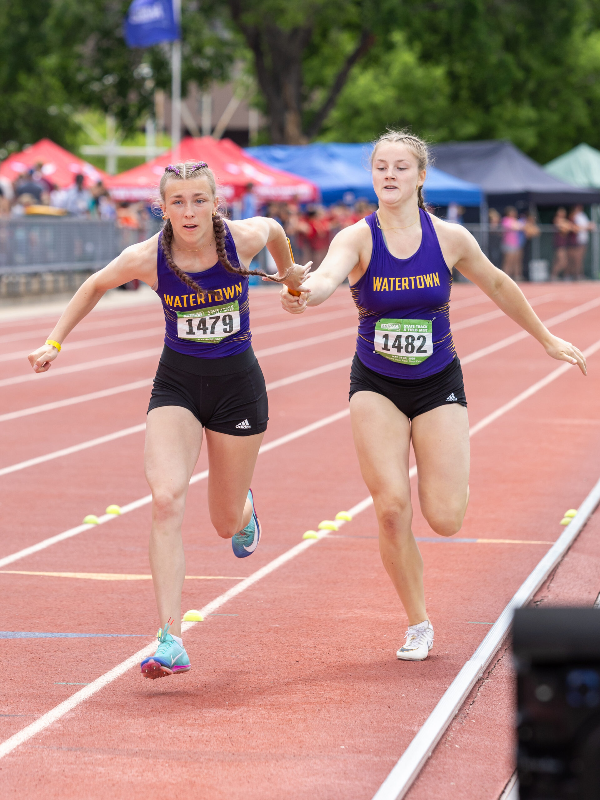 Carighan Klatt passes the baton to Anna Hirtz in the 4x100 meter relay
