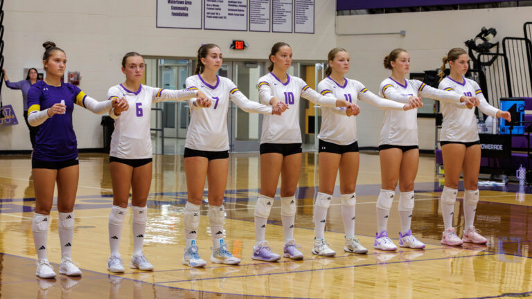 The starting girls swing their arms together while waiting to be introduced